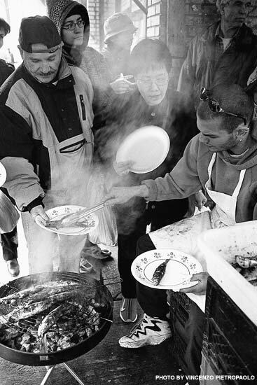 Halder Penacho of Sea Kings Fish Store on Baldwin Street grills sardines, compliments of the house, for passersby on Good Friday, 2000. - Photo courtesy: Vincenzo Pietropaolo